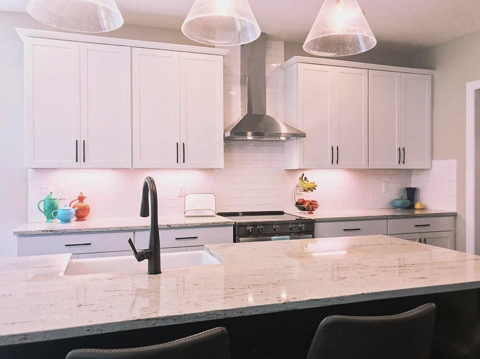 River White granite island in a white shaker kitchen